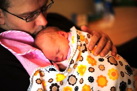 Father cuddling his newborn daughter